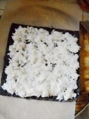 蒸熟的糯米饭放在紫菜上。