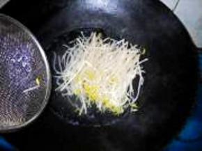 将绿豆芽入开水中焯一下，稍软，过凉水，沥干水分，摆在金针菇上。