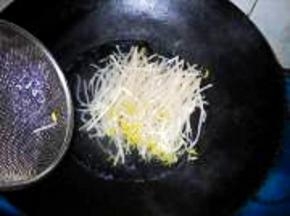将绿豆芽入开水中焯一下，稍软，过凉水，沥干水分，摆在金针菇上。