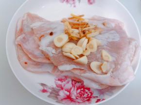 猪颈肉洗净沥干水，加入姜丝蒜片
