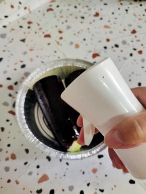 茄子放入锡纸盘里，用喷壶表面喷适量的油！