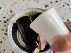 茄子放入锡纸盘里，用喷壶表面喷适量的油！