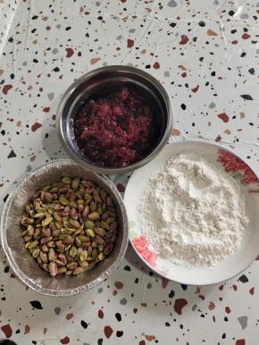 准备馅儿料:
玫瑰花酱355克，低筋面粉120克用微波炉加热2分钟左右就熟了，开心果剥壳后100克！玉米油15克！(拍照的时候忘了拍玉米油了！)(玫瑰花酱里面的糖稀我没有扔掉，所以熟低筋面粉加的有点多，如果你不喜欢糖稀太多，可以把糖稀过滤出来，适当调整熟低筋面粉的用量！)