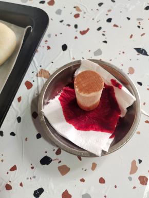 放入一张纸巾浸在红色素里，再把印章放进去，沾上红色！