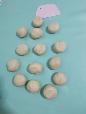 分成14个大小一致的小剂子！揉圆，盖上保鲜膜，再次松弛15分钟左右！(大约一个有55克！)