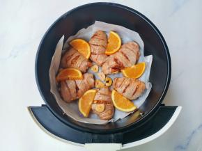 鸡翅码入放好油纸的炸锅，再盖上橙子片，放入预热好的烤箱，200度烤25分钟即可，中途记得翻面。