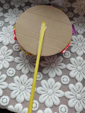 用双面胶把黄色卡纸做的小棒粘在太阳花的背面！