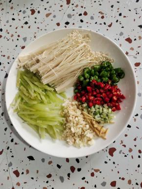 准备好所需的配料:
莴笋去皮洗净切成丝，金针菇去掉根部，清洗干净控干水分，线椒和小米辣切成圈，葱切成末，生姜切成丝，蒜瓣切成小块备用！