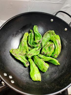 锅烧热，倒少许的油，油热后把辣椒倒入锅中，开小火慢慢的煎！边煎边用铲子轻轻的按压，这样可以快速的起虎皮！切记不要开大火，要不然容易把辣椒煎糊了！一直把辣椒煎成这样的虎皮状就可以了！把辣椒盛出来备用！