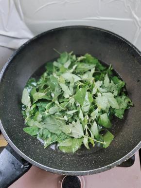 锅中水开加一勺盐和少许食用油，这样能让焯水的灰灰菜更翠绿！倒入灰灰菜！