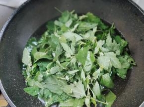 锅中水开加一勺盐和少许食用油，这样能让焯水的灰灰菜更翠绿！倒入灰灰菜！