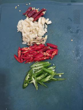 干辣椒切成段，蒜瓣切成小块，生姜切成丝，小米辣和线椒切成滚刀块备用！
