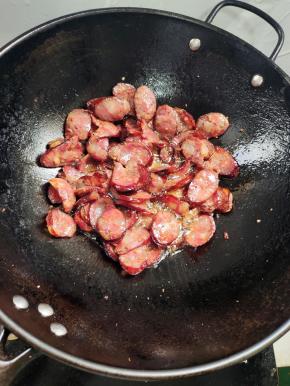 放入熏腊肠煸炒至微卷！