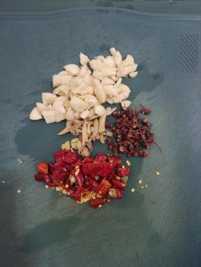 蒜瓣拍碎切成小块，生姜切成小块，干辣椒切成段，准备一小把花椒备用！