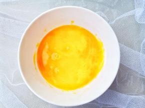 鸡蛋磕入碗中。