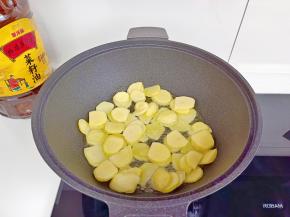 锅里放入金龙鱼外婆乡小榨菜籽油，放入土豆片。