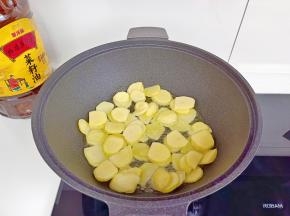 锅里放入金龙鱼外婆乡小榨菜籽油，放入土豆片。