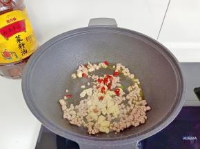 加干辣椒段，蒜片炒香。