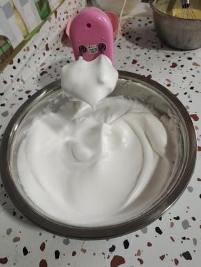 直到打到像图片上这样蛋白打发到有坚挺的小尖角了，再改为低速打发几下，整理一下蛋白里面的气泡。（打发蛋白的时候可以把烤箱预热着！上下火200度预热20分钟）