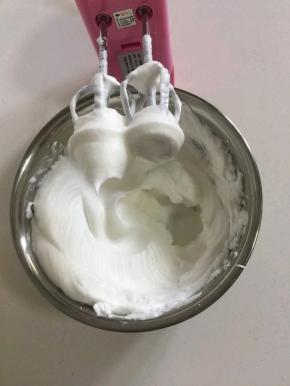 蛋白里面加入2滴柠檬汁(或者白醋），白糖30克分三次加入，用电动打蛋器先高速打发蛋白，感到蛋白有厚重感了改为中速打发蛋白，直到打到像图片上这样蛋白打发到有坚挺的小尖角了再改为低速打发几下，整理一下蛋白里面的气泡。（打发蛋白的时候可以把烤箱预热着！上下火200度预热20分钟)