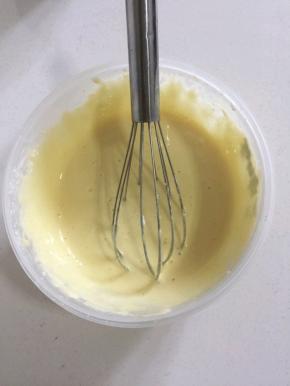 挖三分之一的蛋白到面糊中。用打蛋器上下左右不规则的翻拌均匀！