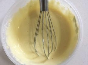 挖三分之一的蛋白到面糊中。用打蛋器上下左右不规则的翻拌均匀！