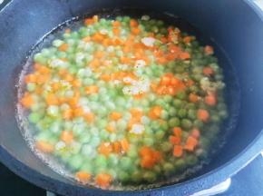锅中烧开水，放入豌豆煮2分钟、再加胡萝卜煮熟捞出。