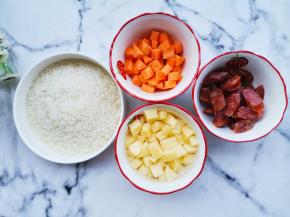 准备好所有食材。胡萝卜和土豆去皮切成小块状，香肠切片，香葱洗净切碎。