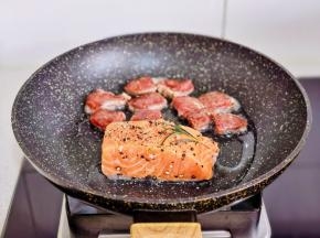 锅中倒入少许橄榄油，放入三文鱼和牛排。