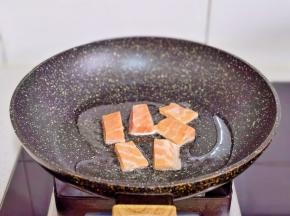 锅中倒入橄榄油，摆入三文鱼块。