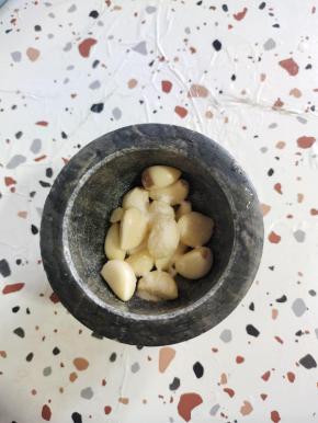 把剥好的蒜瓣放进兑窝里，放入一勺盐！