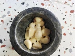 把剥好的蒜瓣放进兑窝里，放入一勺盐！