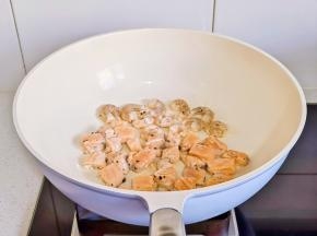 锅中喷油。倒入三文鱼丁和虾仁煎熟盛出。