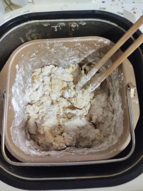 用筷子搅拌一下，以免揉面的时候面粉飞溅，弄脏面包机！