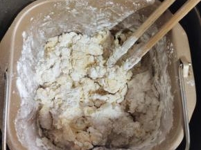 用筷子搅拌一下，以免揉面的时候面粉飞溅，弄脏面包机！