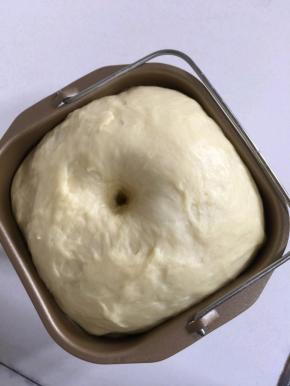 揉好的面团放在面包桶中，常温发酵至两倍大！发酵好的面团，用手指沾一点儿面粉，在面团中间按一下，面团不轻易回缩就说明发酵好了！