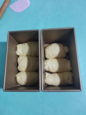卷好的面团放进吐司盒，收口的地方朝下。