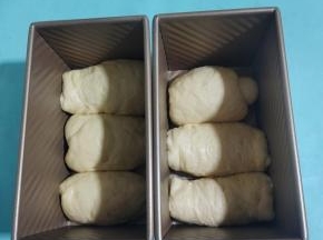 卷好的面团放进吐司盒，收口的地方朝下。