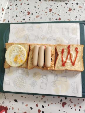 挤上适量的番茄酱，再放上烤好的鸡蛋和火腿肠！