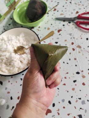 这样就可以折出一个明显的尖角！然后再从后面顺着纹路给他严严实实的包起来！西米粽子一定要包严实，不能露米，不然煮的时候容易飞米！
