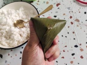 这样就可以折出一个明显的尖角！然后再从后面顺着纹路给他严严实实的包起来！西米粽子一定要包严实，不能露米，不然煮的时候容易飞米！