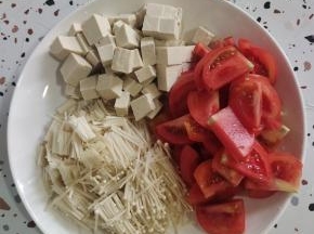 西红柿切成片，豆腐切成小块，金针菇去掉根部清洗干净切成段备用！