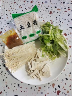 准备好所需的食材:豆腐切成条，奶白菜清洗干净切成段，酸汤肥牛调料1包(40克），土豆粉1袋(200克），葱切成葱花，金针菇去掉根部，清洗干净，挤干水分备用！