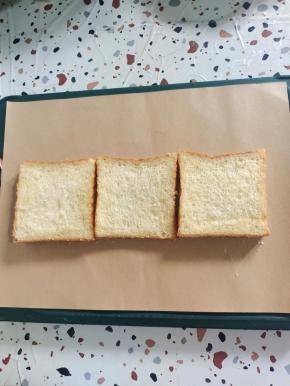 把加厚小熊包装纸平铺在干燥的案板上，准备三片吐司！