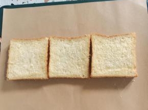 把加厚小熊包装纸平铺在干燥的案板上，准备三片吐司！