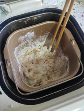 用筷子搅拌一下，以免揉面的时候面粉飞溅，弄脏面包机！