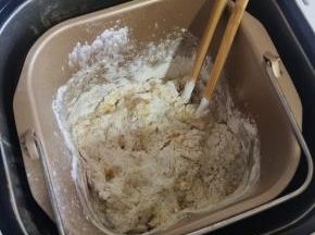 用筷子搅拌一下，以免揉面的时候面粉飞溅，弄脏面包机！