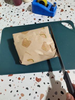 两边也用胶带固定一下，以免切的时候容易散开！再用面包刀把四周拍打一下！