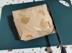 两边也用胶带固定一下，以免切的时候容易散开！再用面包刀把四周拍打一下！