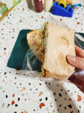 透明包装纸整理一下，把做好的奥尔良鸡排三明治斜着放进去！